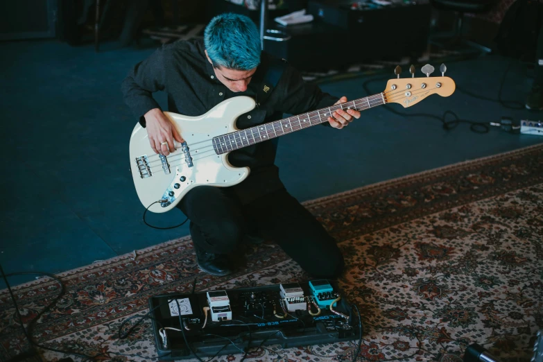 the man is playing his electric guitar in the music studio