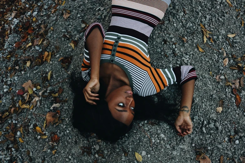 a woman is laying on the ground looking down