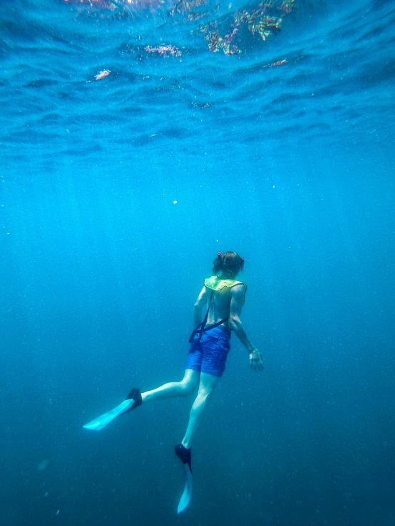 a woman snorkling on the water with her fins up