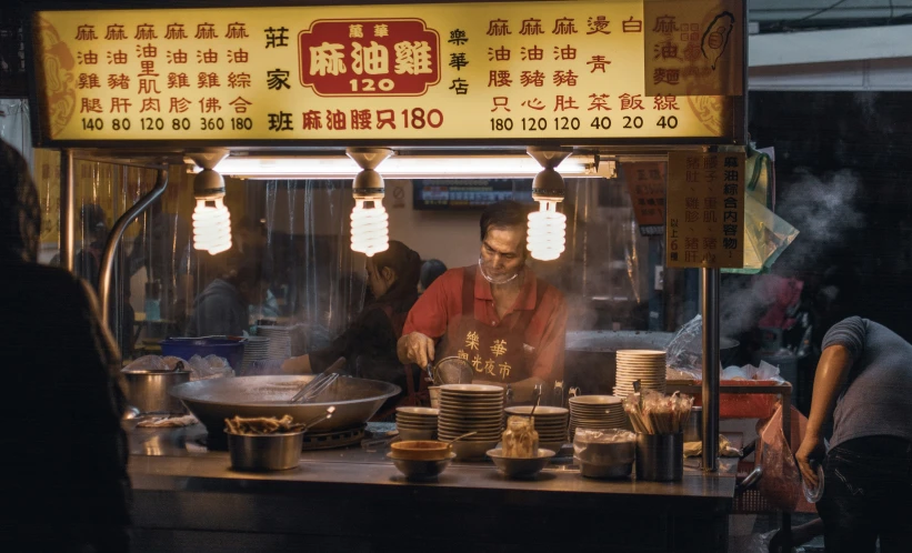 the man stands behind the food cart in china