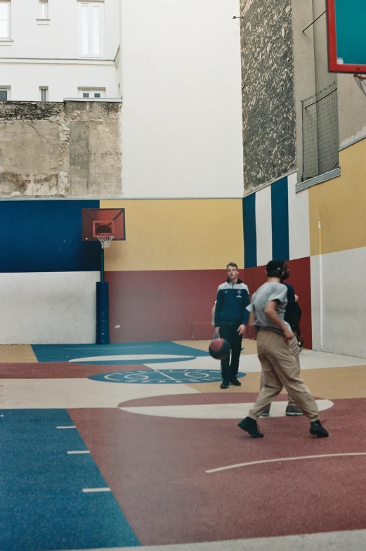 a group of people are playing basketball in a basketball court