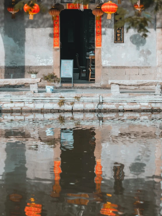 a house in the rain with lanterns hanging over the doorway