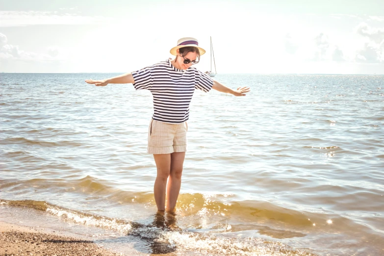 the man in striped shirt is standing on the water