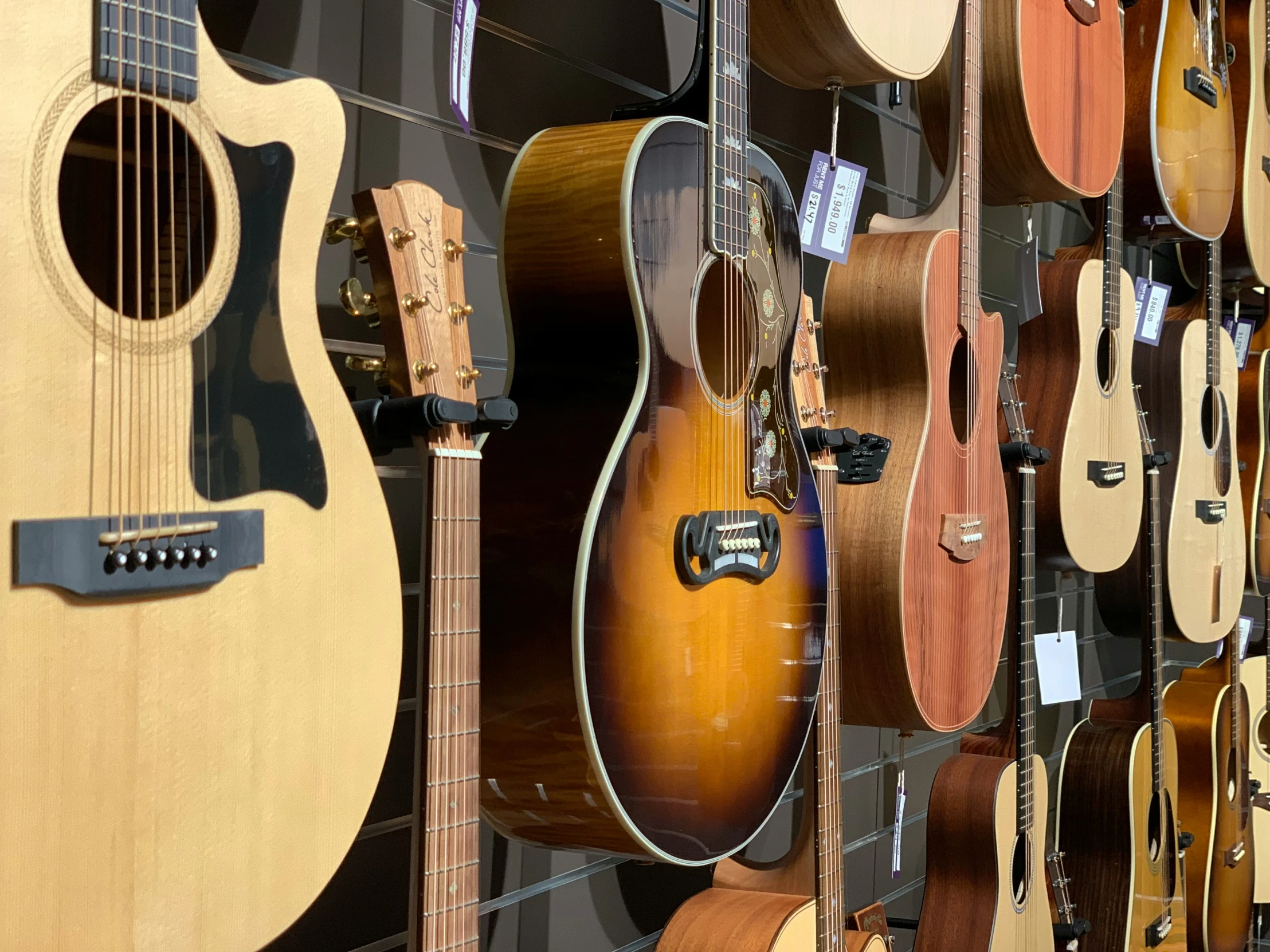 a wall full of guitars in the background