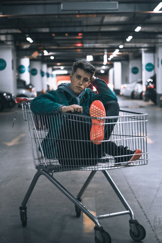 a man in blue jacket sitting in shopping cart