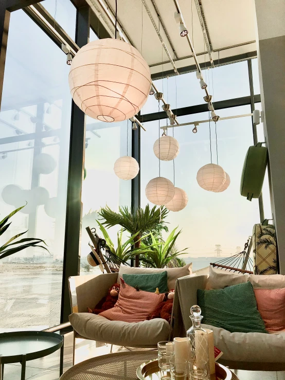 several colorful pillows sit on a couch near large windows