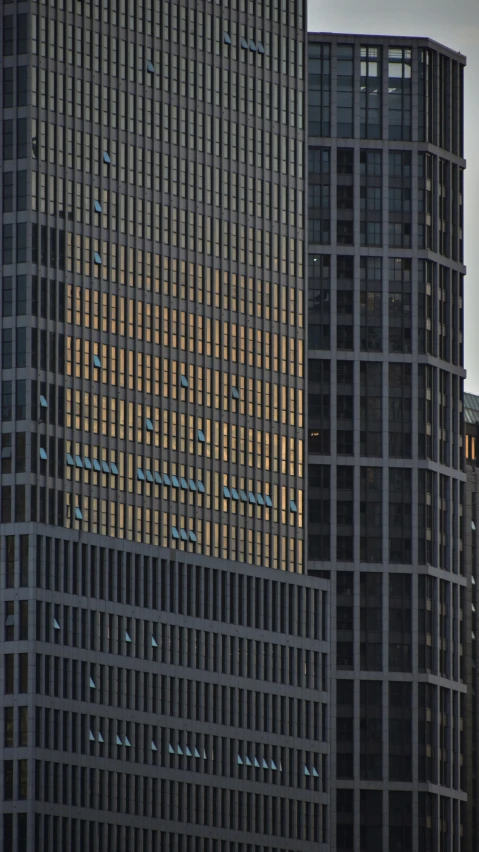 the top of a very tall skyscr has a large clock on it