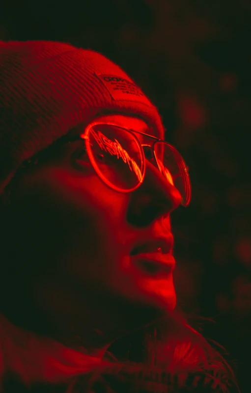 a person wearing red glasses while looking off to the side