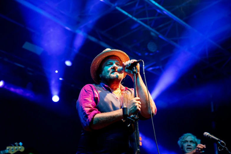 a man standing on stage with microphone in front of him