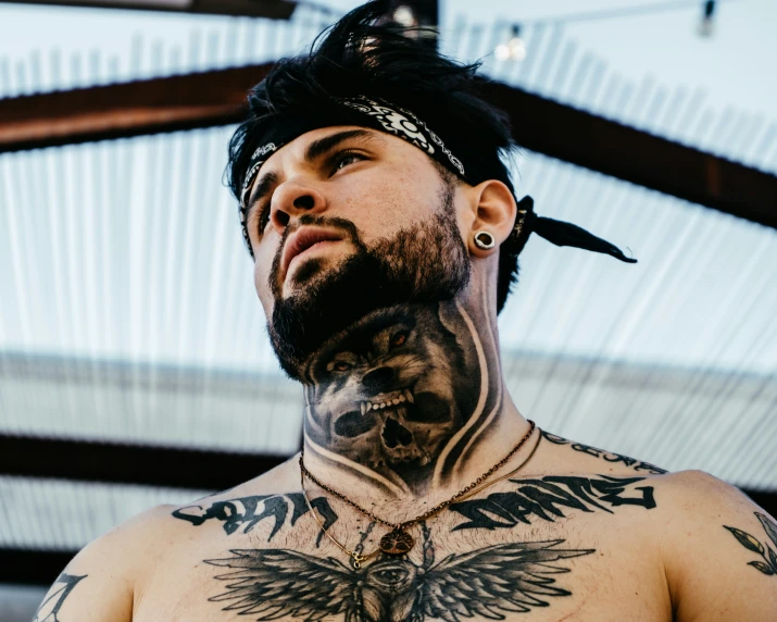 a man with a bird and eagle tattoo on his chest