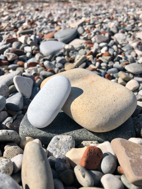 a small rock sits on some rocks near the water