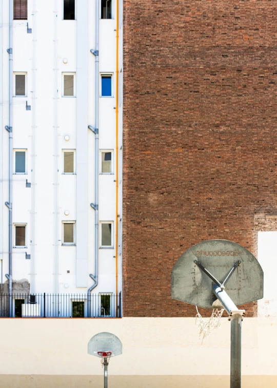 a basketball hoop stands in front of a large brick building