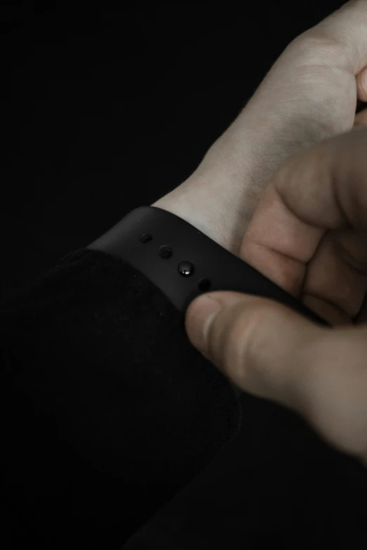 a hand holding onto the strap of a wrist watch