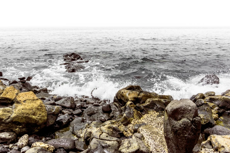 an ocean scene with rocks and waves