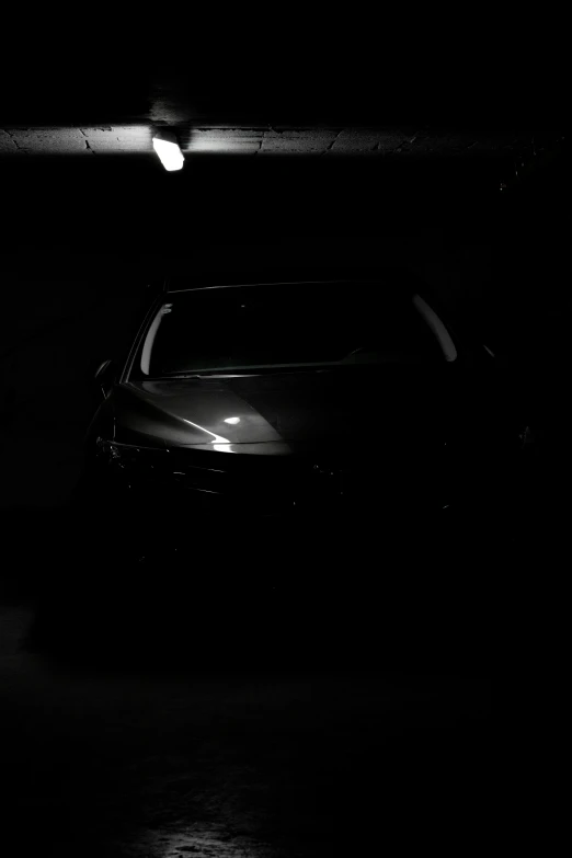 a dark room with only a car and a light