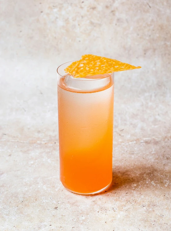 an orange drink in a glass with a little yellow straw garnish