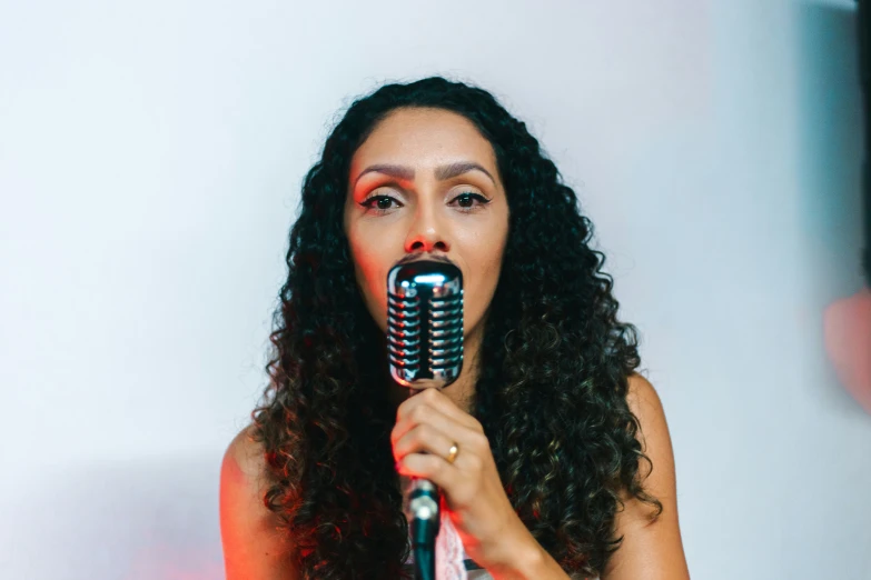 woman wearing red holding microphone and performing a song