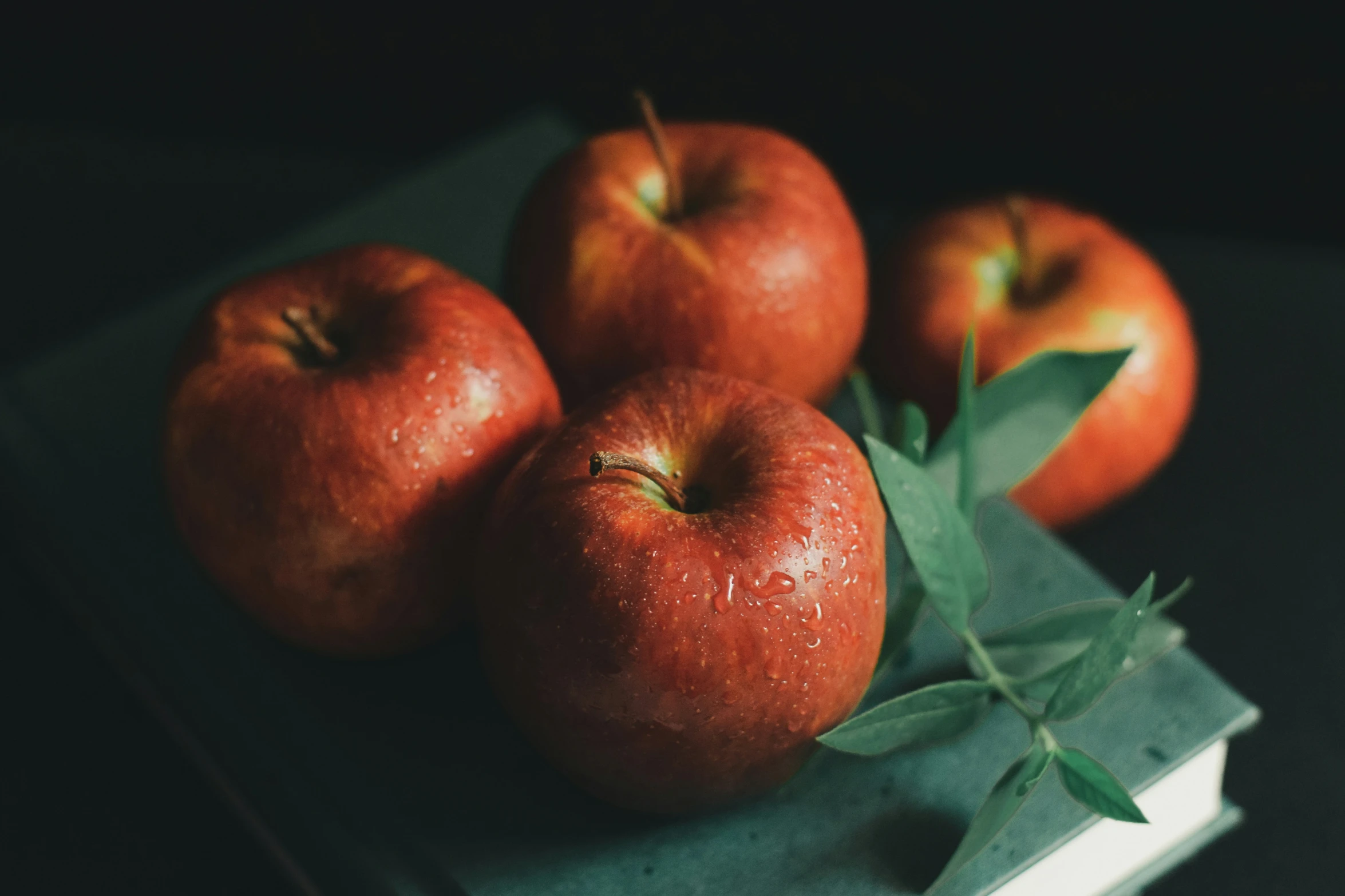 four red apples are on top of green napkins