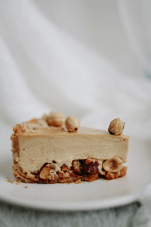 a piece of cheesecake with nuts is sitting on a plate