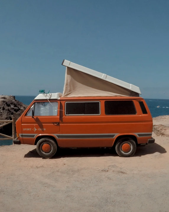 a van is set up on a beach with the door open