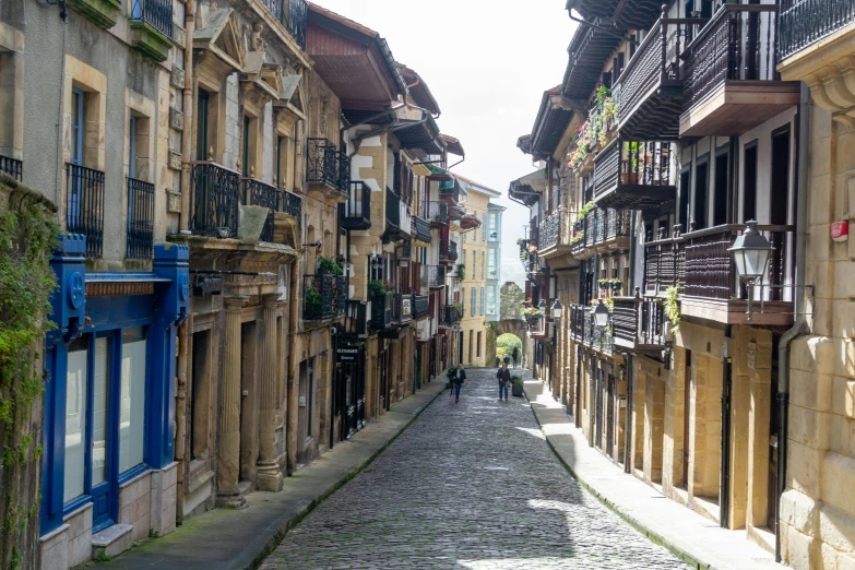 an empty street with two people walking by