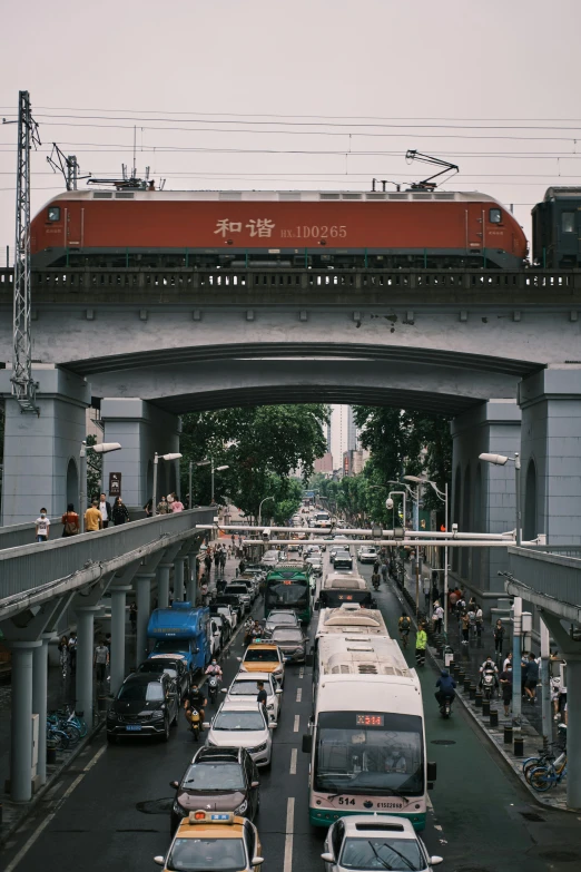 a train on tracks above cars and people