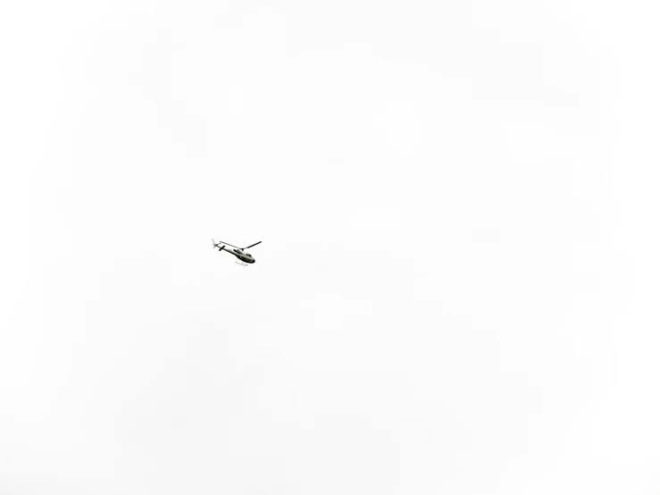 an airplane is flying through a white sky