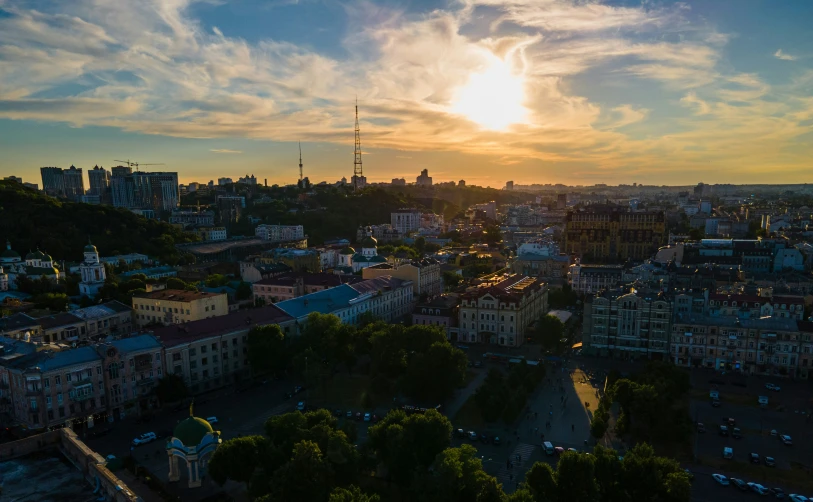 a colorful sunrise shines in front of some tall buildings