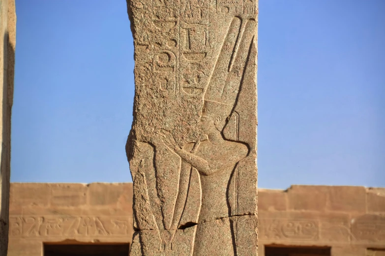 a carving of an egyptian bird sits in front of two smaller blocks