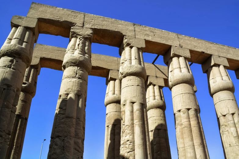 columns from the ruins of a palace stand against a blue sky