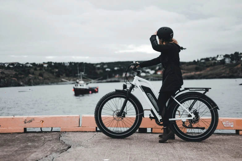 the person is taking pictures on their cell phone next to their bicycle