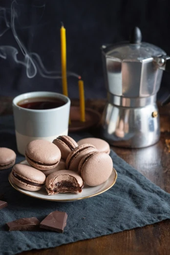 a table with a cup of coffee and some macaroons on it