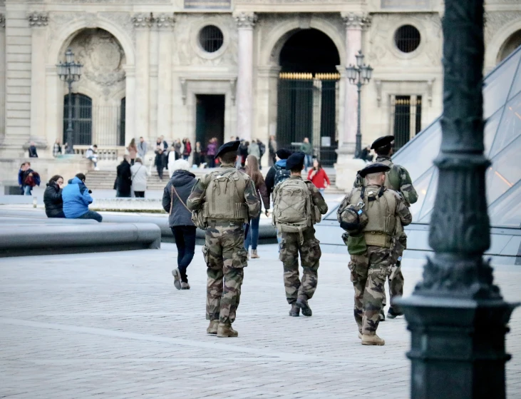 soldiers walking in formation to patrol down a sidewalk