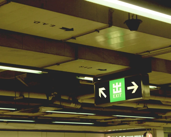exit sign mounted to the ceiling of a subway stop
