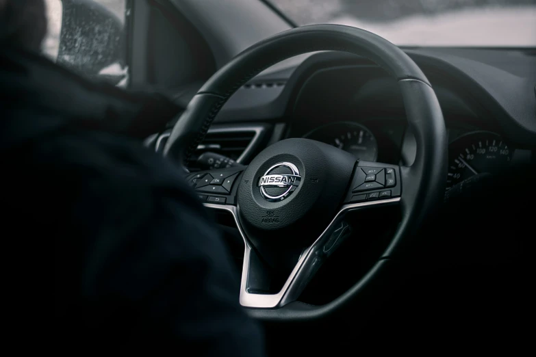 a man driving a car with a steering wheel