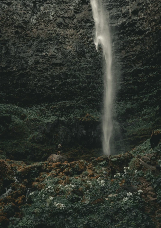 a waterfall spilling into a green cliff side