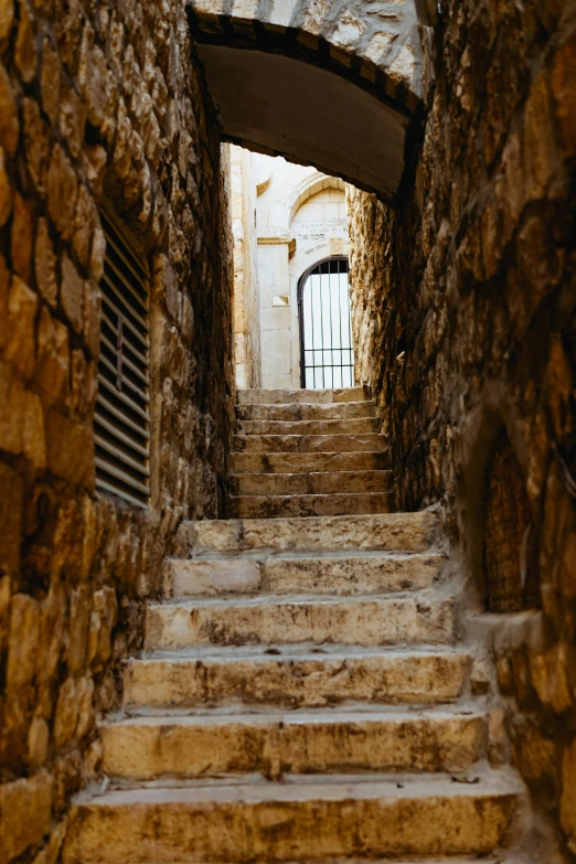 a stone stairway is seen through an archway