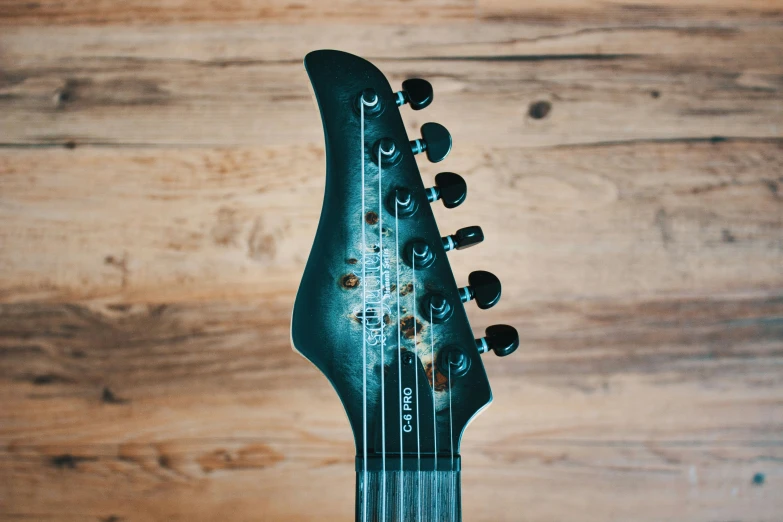 a black and chrome electric guitar with a wooden back ground