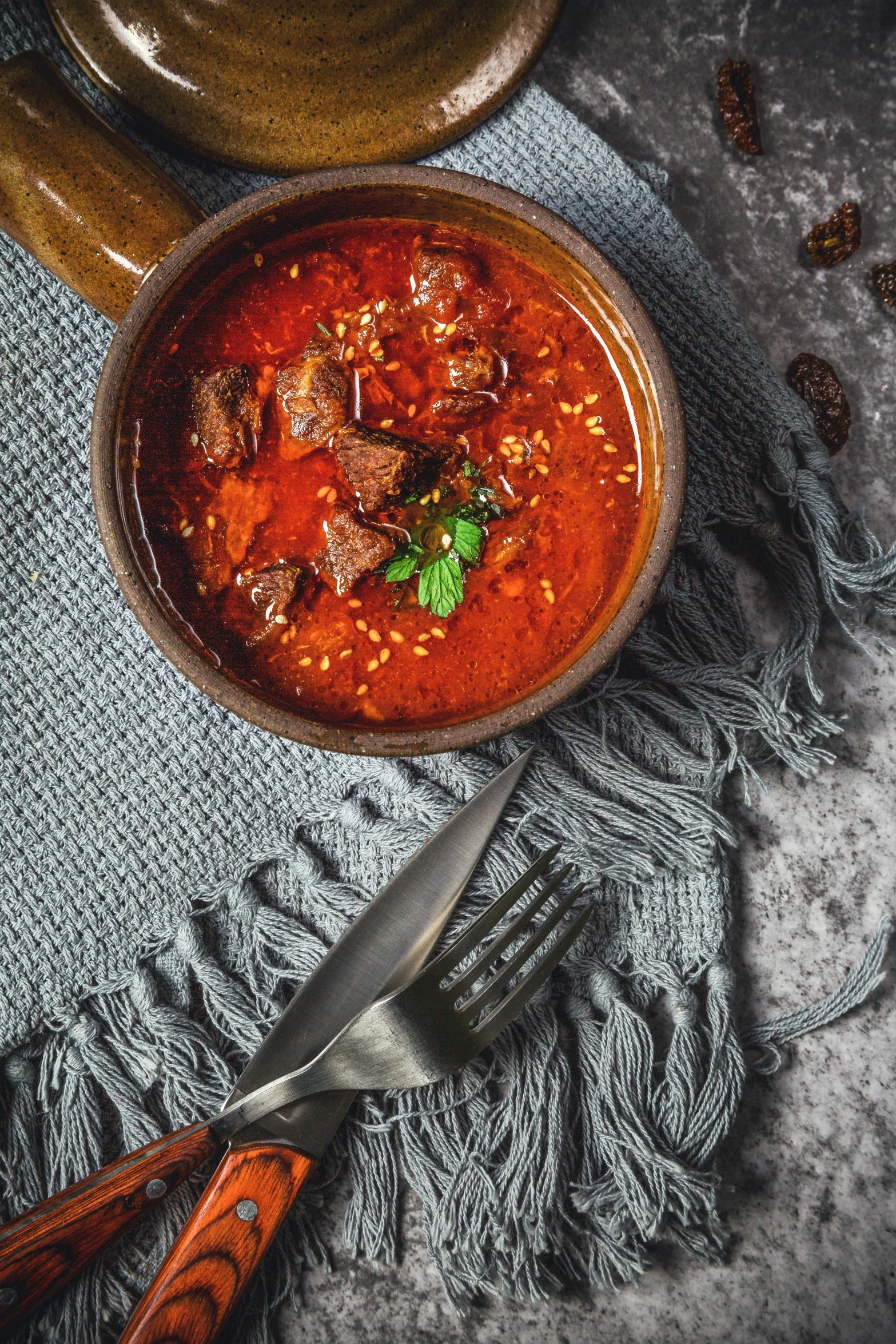 the bowl of soup is on a silver plate