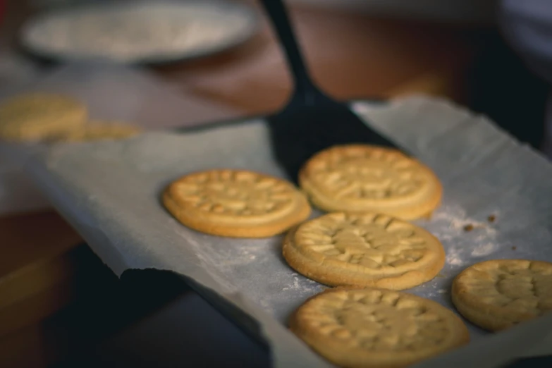 a group of cookies sit in the pan with a spatula