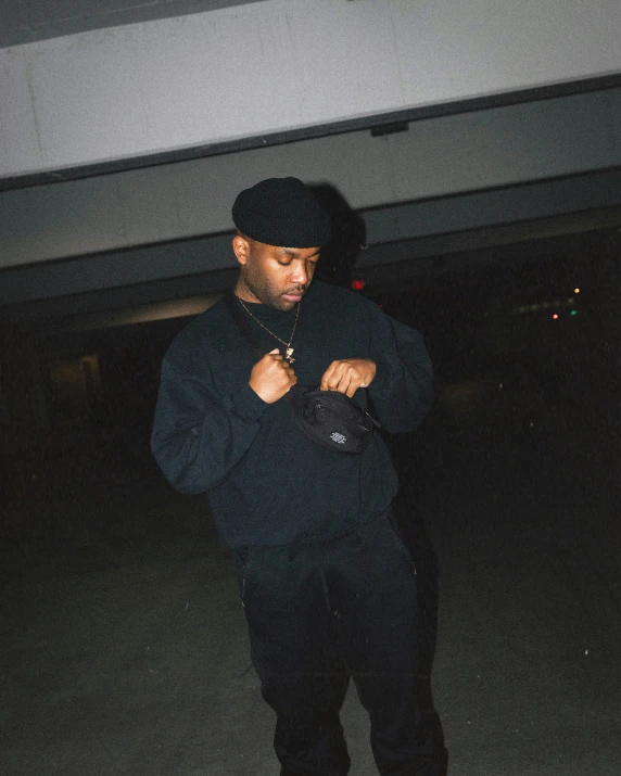 a man in black standing in front of a building