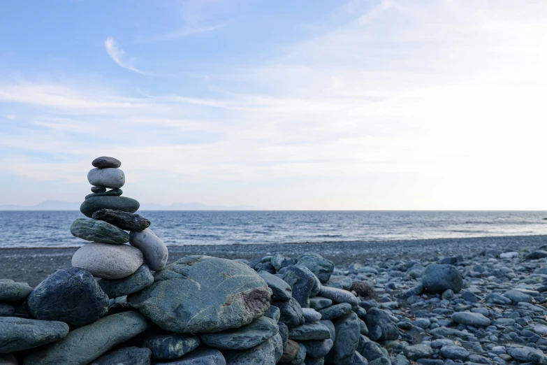 a stack of rocks in front of the ocean