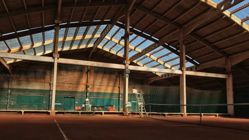 an outdoor tennis court with a large glass roof