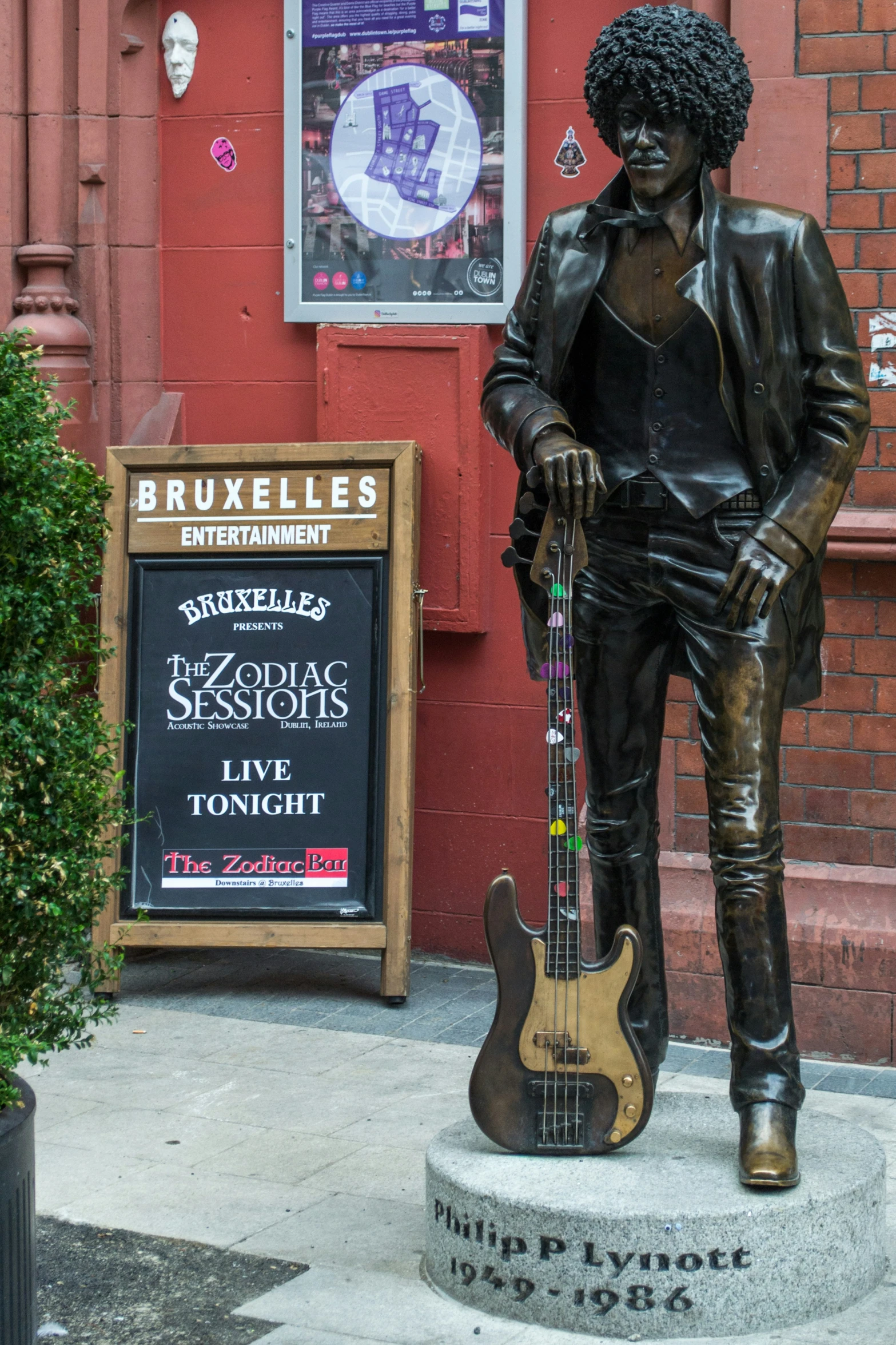 there is a guitar statue on the side of the street