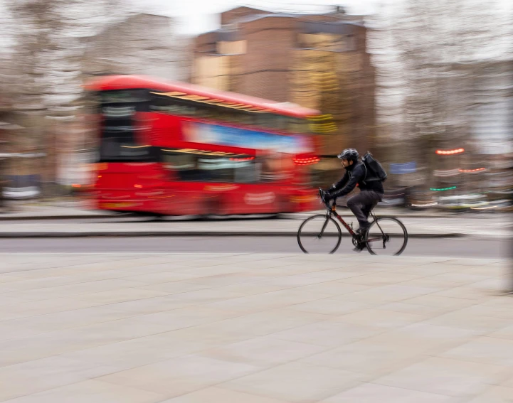 a blurred image of a person on a bike riding in the street