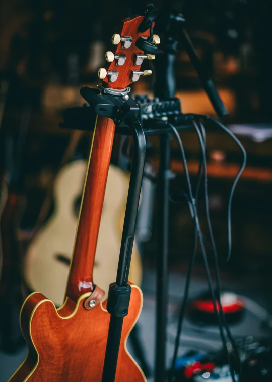 a guitar on a stand with other guitars