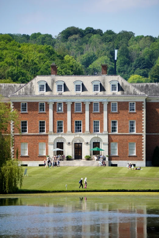 a large brick building sitting on top of a lush green field