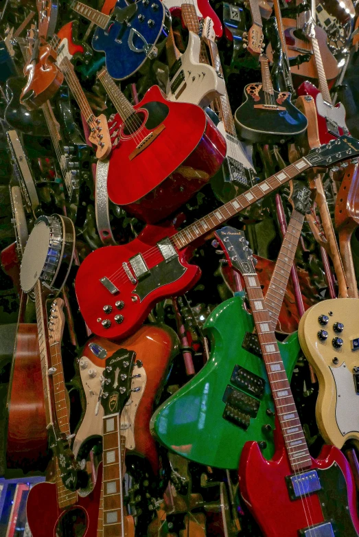 the colorful guitars are all stacked up and ready to be used