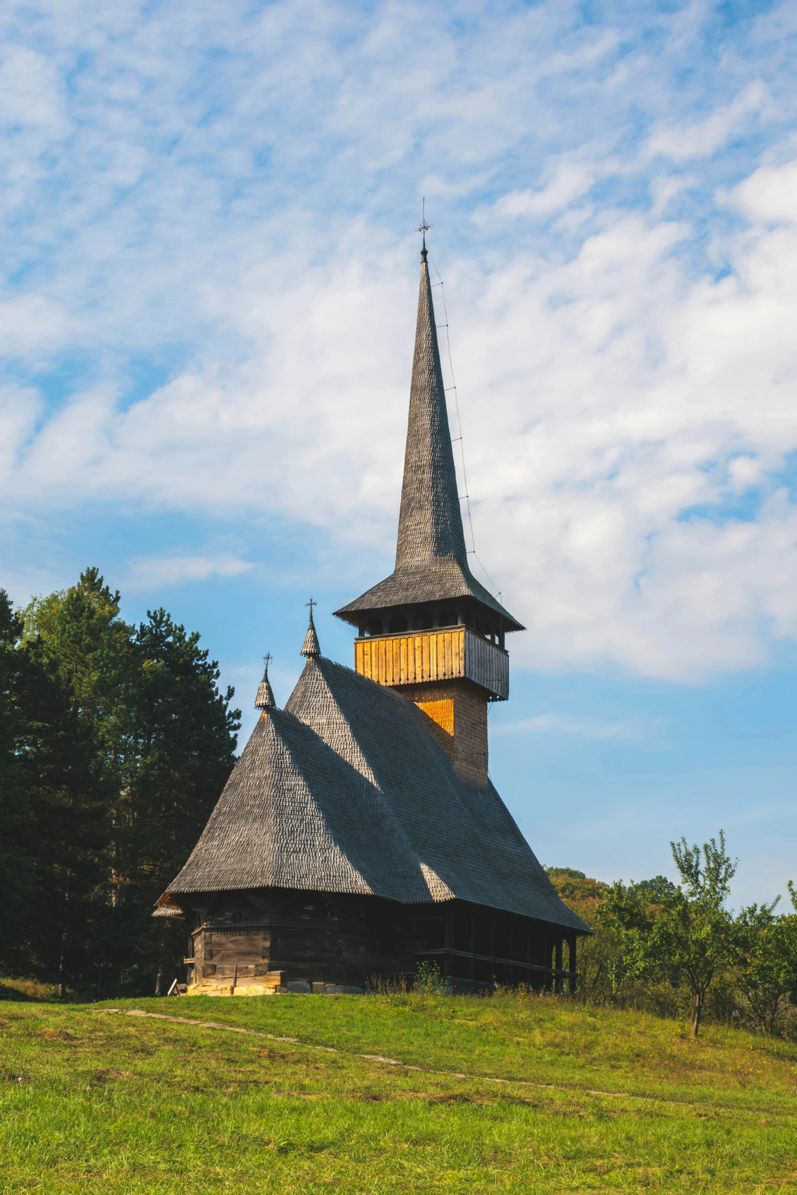 an old church sitting on top of a lush green hill