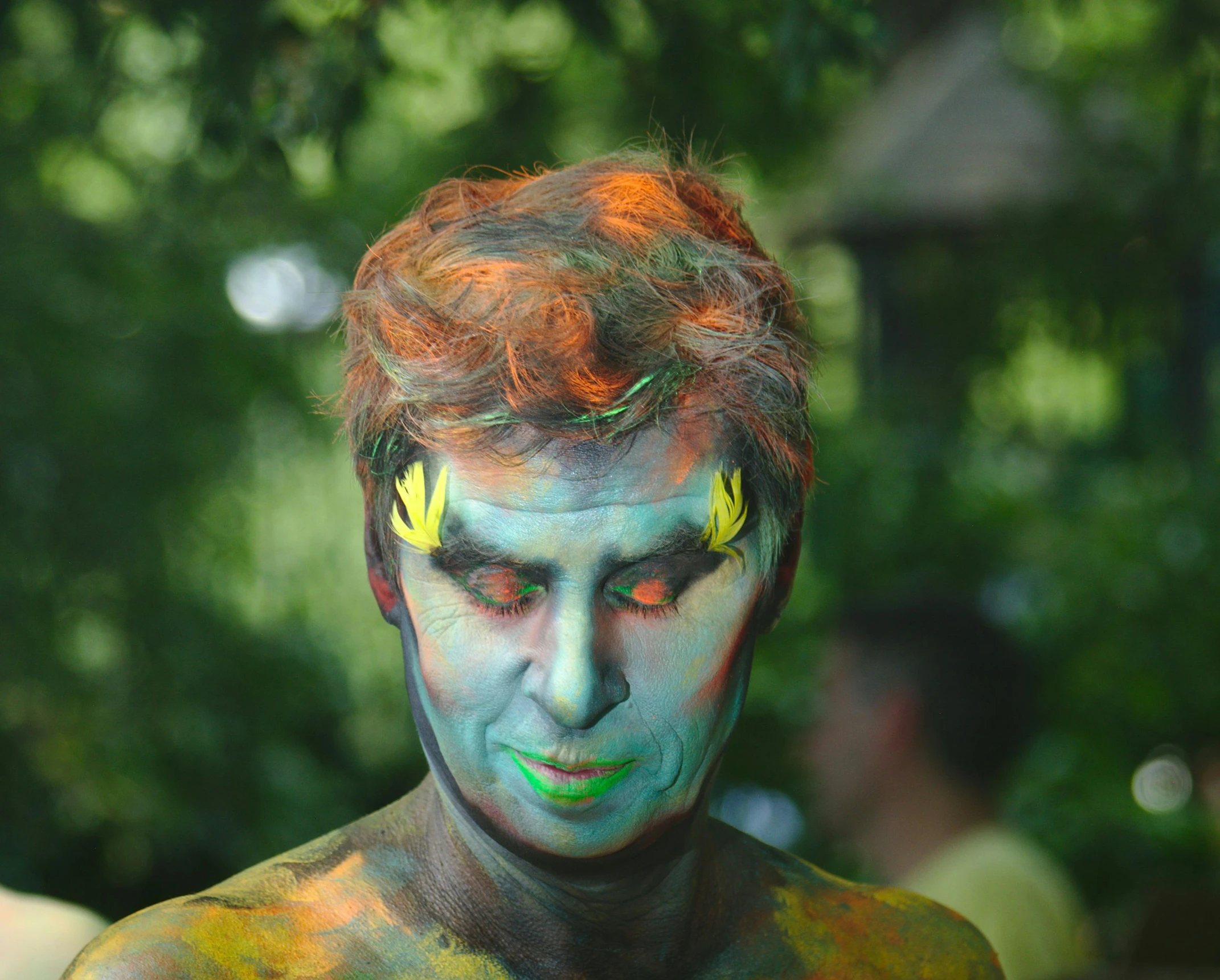 a man with face paint has his eyes painted yellow and orange